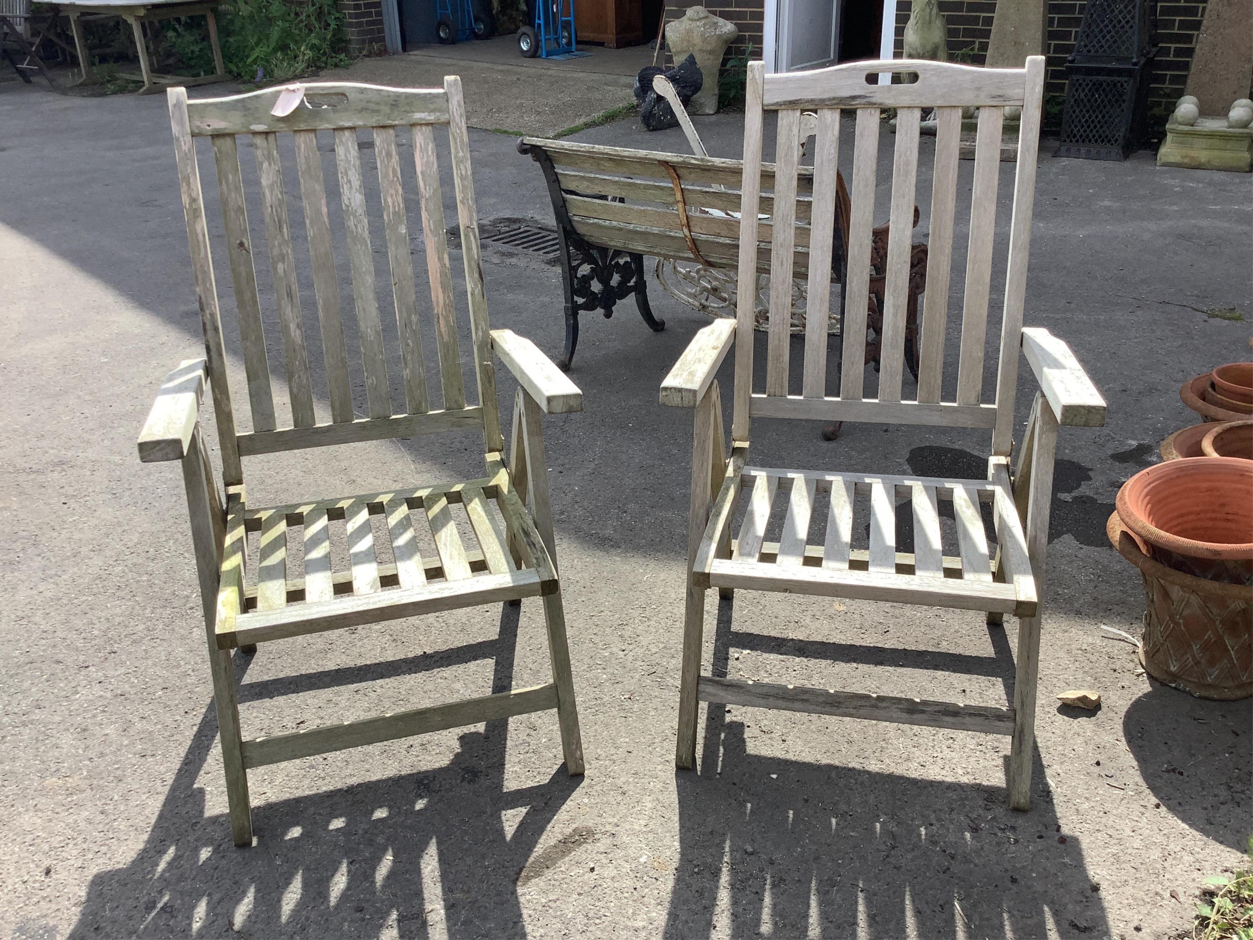 A weathered teak extending garden table, width 210cm extended, depth 120cm, height 75cm, together with six (four plus two) stained teak garden armchairs. Condition - fair